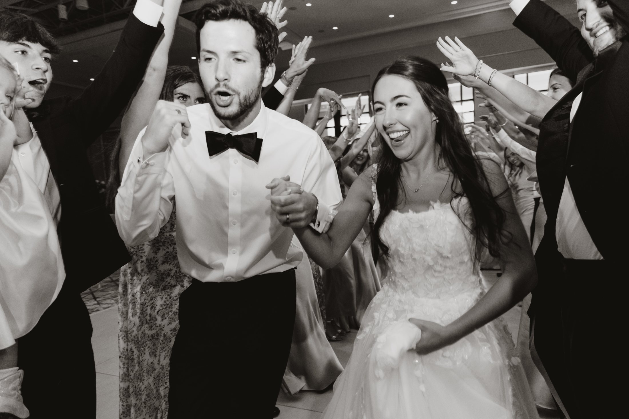 A bride and groom dancing through a circle of cheering guests at a north Georgia wedding reception