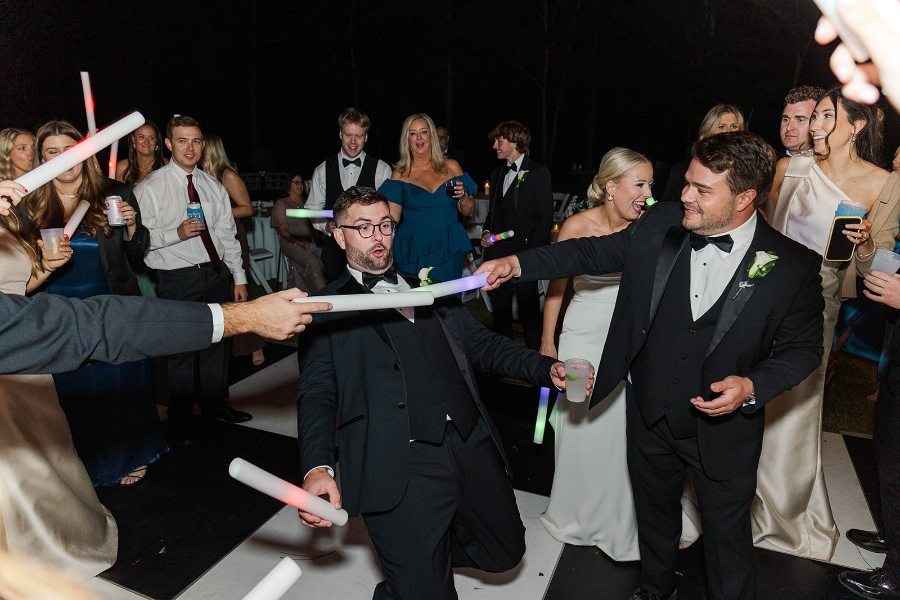 Guests waving glow sticks around the groom on the dance floor at a north Georgia reception