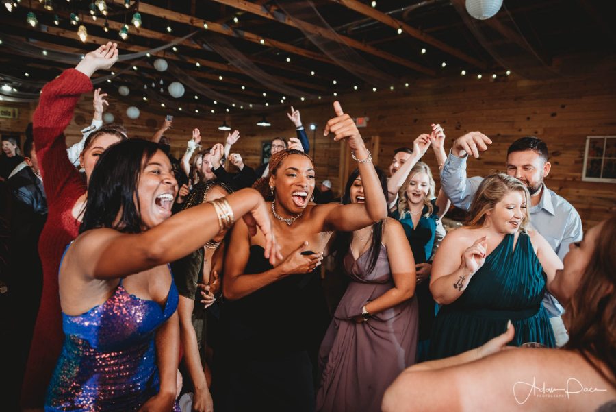 Guests filling the dance floor under string lights at a Georgia barn reception, photo by Adam Pace Photography