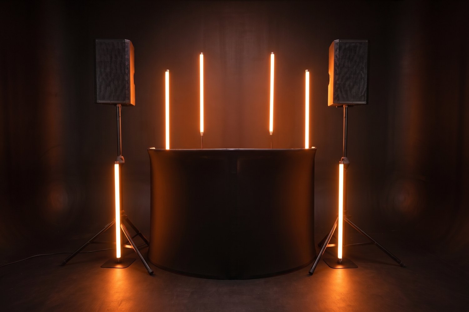 The same DJ booth framed by six Nightbird Neon tubes in party mode