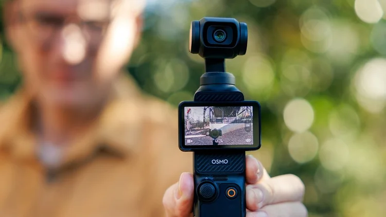A handheld gimbal camera filming a Nightbird event, the shot visible on its screen