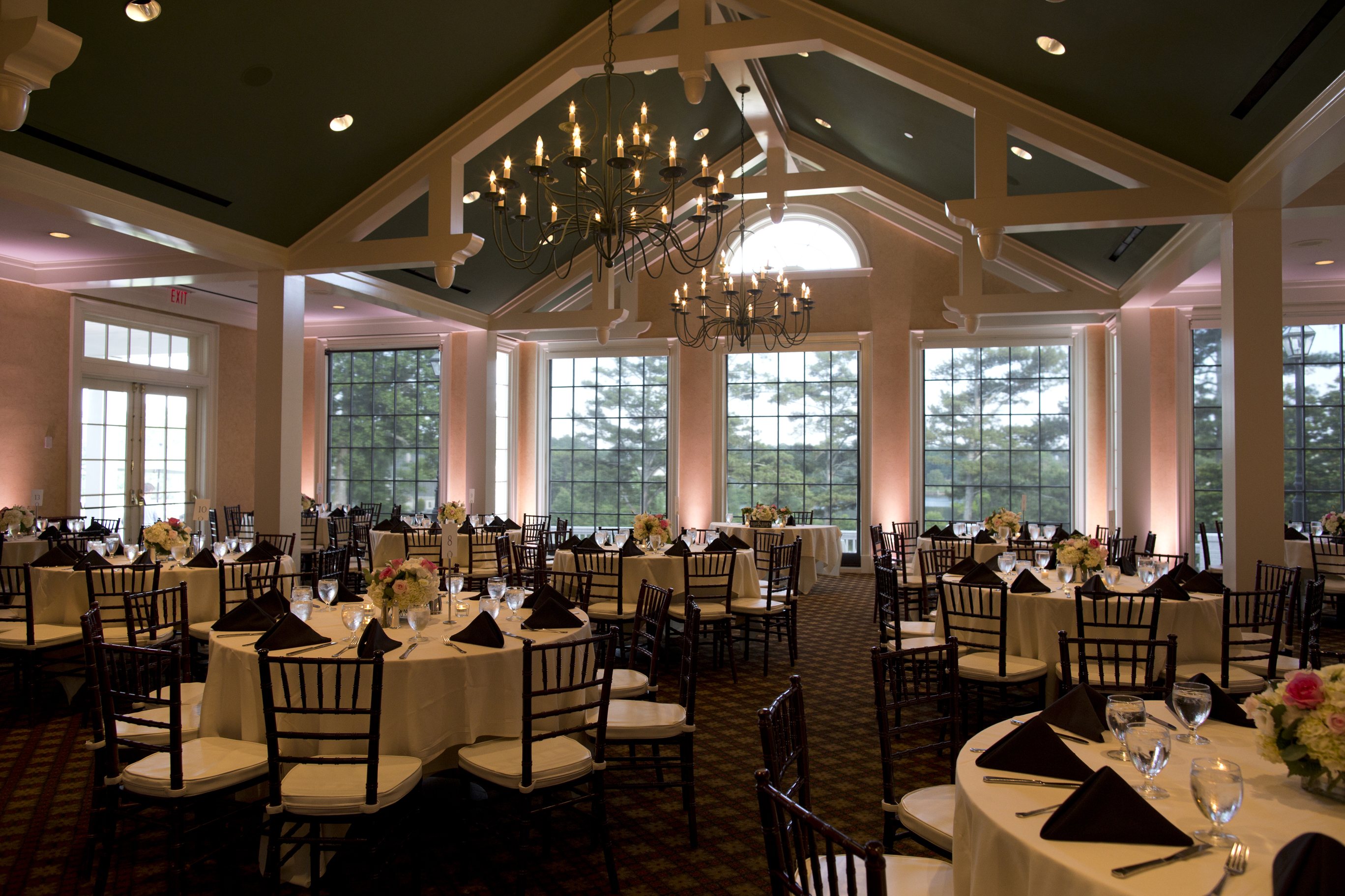 A reception room washed in soft blush uplighting